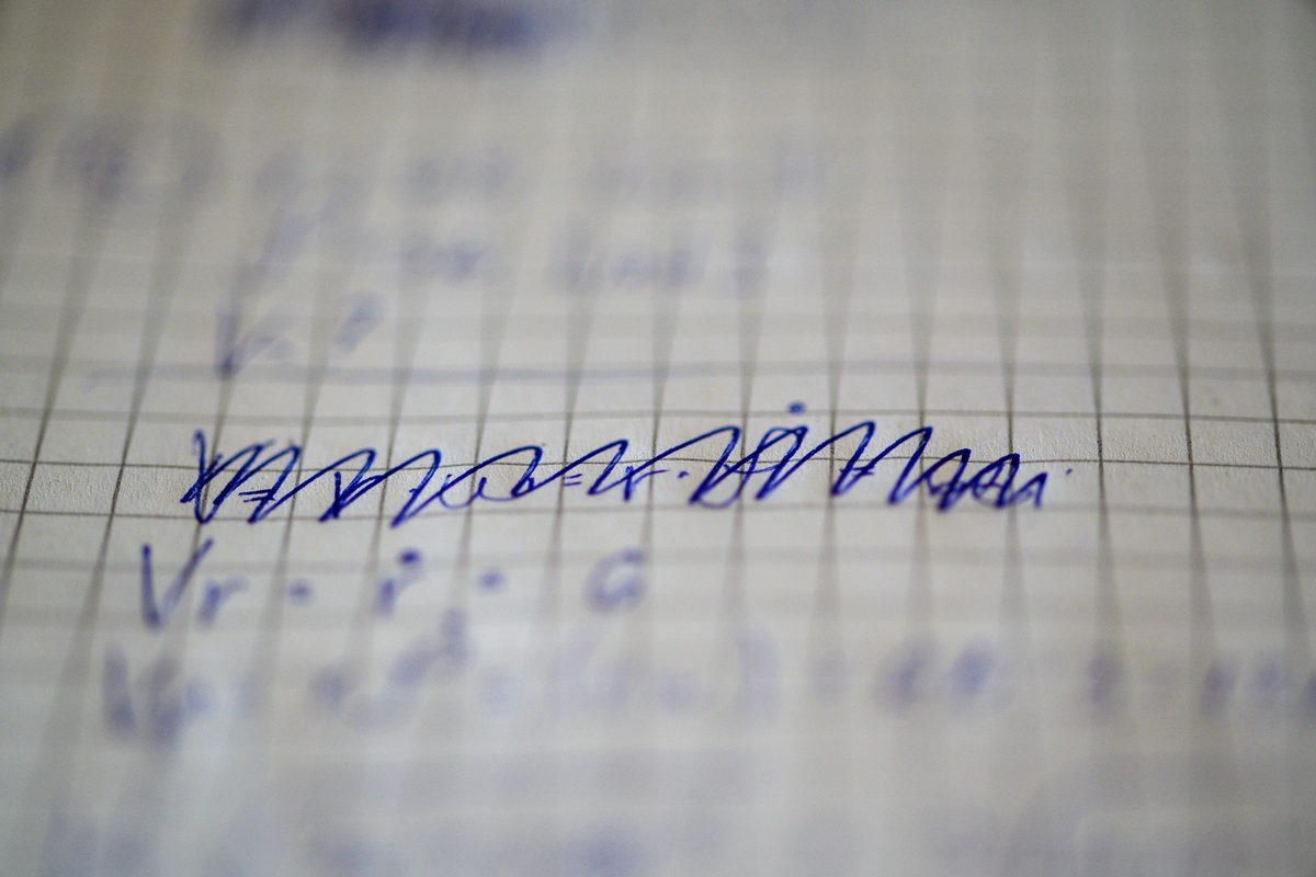 Close-up of handwritten corrections on a grid-lined page